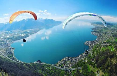 two paragliders flying over a body of water at Villa Rose in the center of Montreux by GuestLee in Montreux