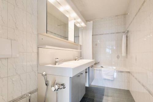 モントルーにあるAlpine Stunning Apartment in Montreux by GuestLeeの洗面台と鏡のある白いバスルーム