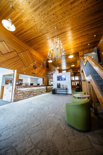 a large room with a wooden ceiling and a chandelier at Mountaineer Lodge in Lake Louise