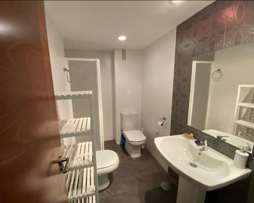 a bathroom with a white toilet and a sink at Sego Apartments I in Segovia
