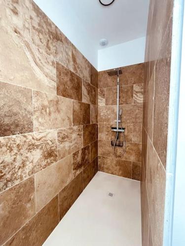 La salle de bains est pourvue d'une douche et d'un mur carrelé. dans l'établissement Villa André à Nîmes, à Nîmes