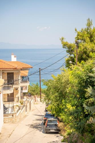 a street with cars parked next to a house at Kyklon Maisonette in Afitos
