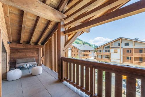 - un balcon en bois avec un lit et des chaises dans l'établissement 4 bedroom duplex with large balcony and parking, à Megève
