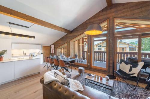 un salon avec un canapé et une table avec des chaises dans l'établissement 4 bedroom duplex with large balcony and parking, à Megève