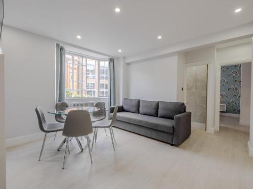 a living room with a couch and a table and chairs at Chelsea Cloisters Serviced Apartments in London