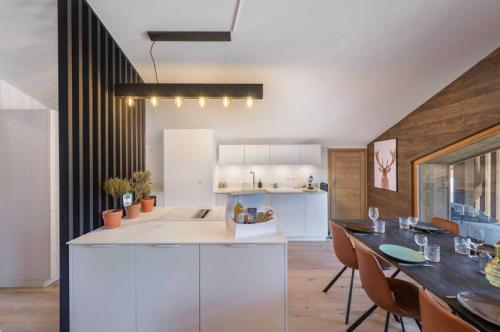 une cuisine et une salle à manger avec une table et des chaises dans l'établissement 4 bedroom duplex with large balcony and parking, à Megève