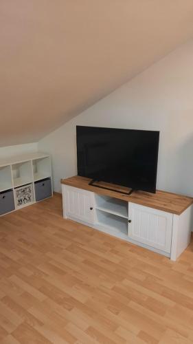a living room with a flat screen tv on a white wall at útulný podkrovní byt v centru Třebíče in Třebíč