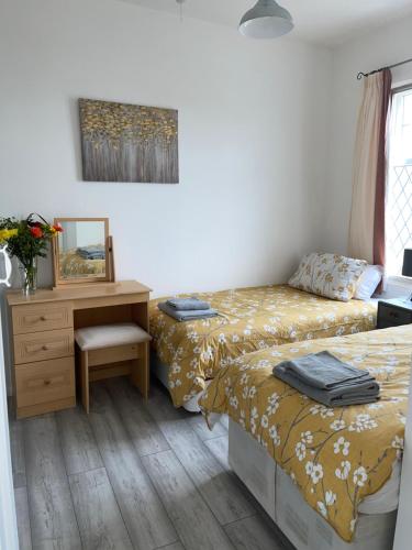 a bedroom with two beds and a desk and a mirror at Beautiful home in central Bishop Auckland town in Bishop Auckland