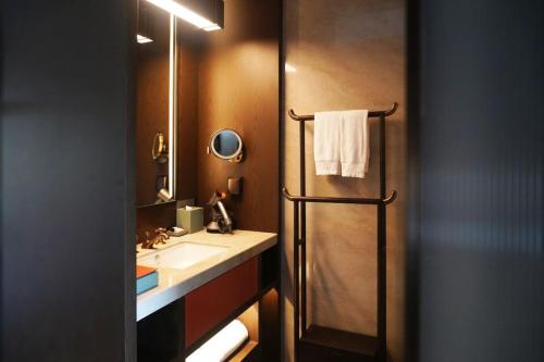 un bagno con doccia, lavandino e specchio di 西安曲江芳林苑酒店 a Xi'an