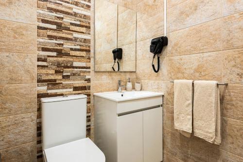 a bathroom with a toilet and a sink at Madalena Hostel e Suites in Faro