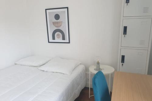 - une chambre avec un lit et une table avec une chaise bleue dans l'établissement Flexliving - room - Voltaire, à Paris