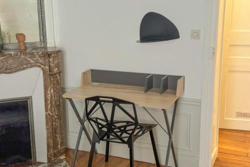 - un bureau avec une chaise près de la cheminée dans l'établissement Flexliving - room - Bachaumont, à Paris