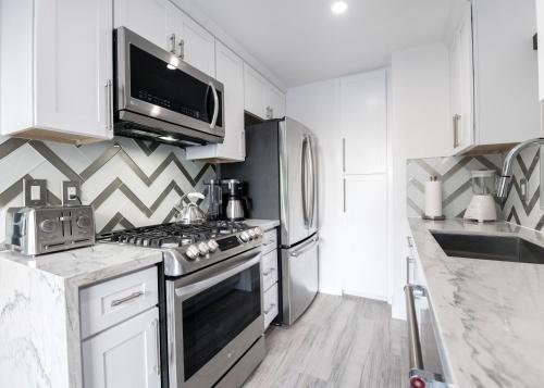 a kitchen with a stove and a microwave at 5 Bedrooms in Newport Beach