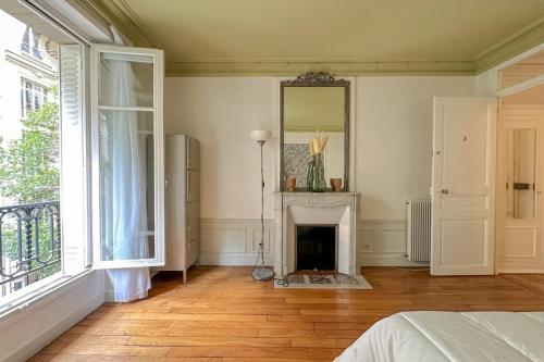 - une chambre avec une cheminée et un miroir mural dans l'établissement Flexliving - room - Bachaumont, à Paris