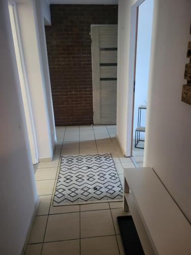 un couloir avec un tapis sur un sol carrelé dans l'établissement APARTAMENT PRZY WYSPIE, à Darłowo