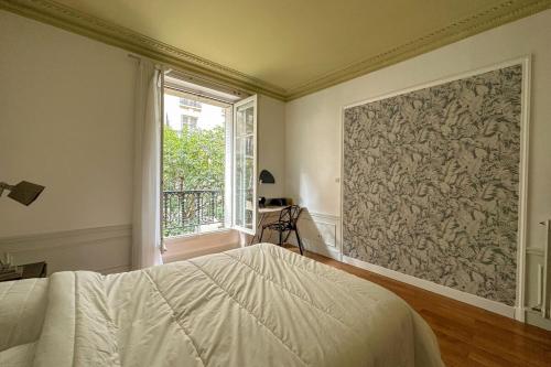 une chambre avec un lit et une grande fenêtre dans l'établissement Flexliving - room - Bachaumont, à Paris