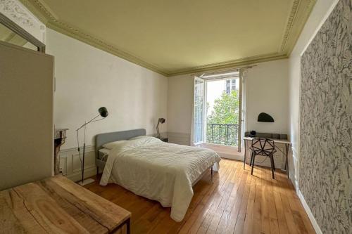 une chambre avec un lit et une grande fenêtre dans l'établissement Flexliving - room - Bachaumont, à Paris