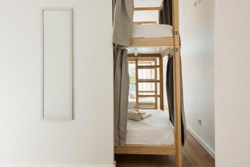 a room with two bunk beds and a window at Madalena Hostel e Suites in Faro