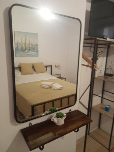 a bedroom with a bed and a large mirror at Ενοικιαζόμενα Δωμάτια "ΜΕΡΣΙΝΗ" in Karistos