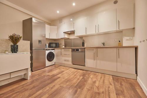 une grande cuisine avec des placards blancs et des appareils en acier inoxydable dans l'établissement Classy Apartment 2BD-4P - Eiffel Tower, à Paris