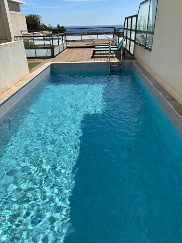 une piscine avec de l'eau bleue devant un immeuble dans l'établissement BANDOL Magnifique appartement Vue mer Résidence Blue Bay, à Bandol
