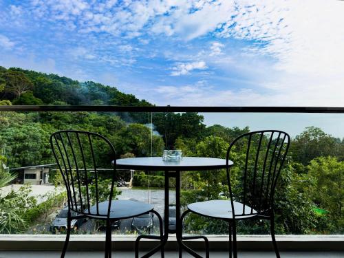 a table and two chairs on a balcony with a view at The Viva Patong in Patong Beach