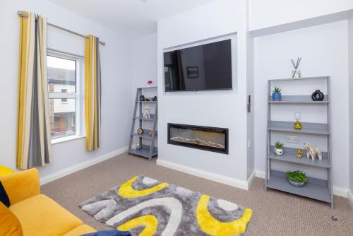 a living room with a fireplace and a tv at MODERN 2 BeD APARTMENT in Enniskillen