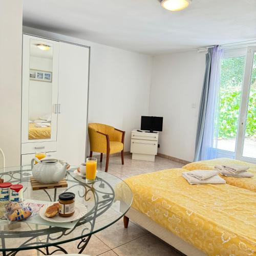 une chambre avec deux lits et une table en verre dans l'établissement Studio agréable en forêt, à Saint-Jouan-des-Guérets