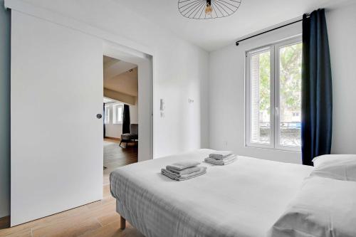 une chambre blanche avec un lit et une fenêtre dans l'établissement Refreshing 2BD-6P apartment - 18th ard, à Paris