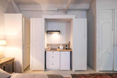 une pièce avec une petite cuisine avec des armoires blanches dans l'établissement Studio de Charme in the heart of Cannes, à Cannes