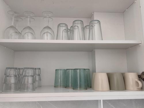 a shelf filled with glasses and vases at Marina view seaside apartment in Larnaka