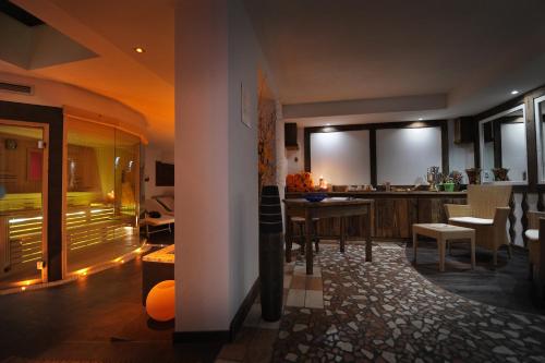 a kitchen and living room with a table and chairs at Hotel Bella di Bosco in Malè