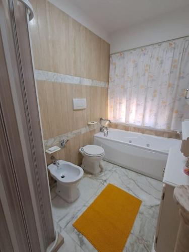 a bathroom with a toilet and a tub and a sink at CasaLina Apartment in Manduria