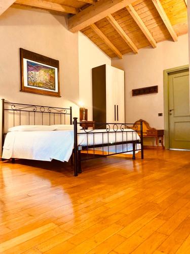 a bedroom with a bed and a wooden floor at La Casina in Dello