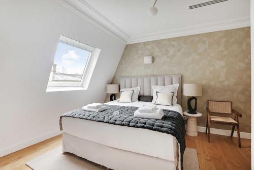 une chambre avec un grand lit et une fenêtre dans l'établissement Sumptuous Apartment - 4CH-8P - Champs Elyséees, à Paris