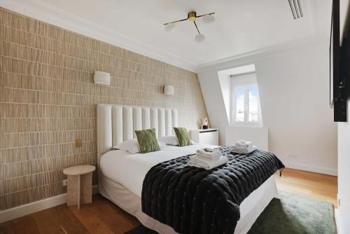 une chambre avec un lit avec une couverture noire et blanche dans l'établissement Sumptuous Apartment - 4CH-8P - Champs Elyséees, à Paris