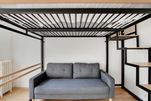 - un canapé dans une chambre avec une mezzanine dans l'établissement Cozy studio - 2P - Grenelle-Eiffel Tower, à Paris