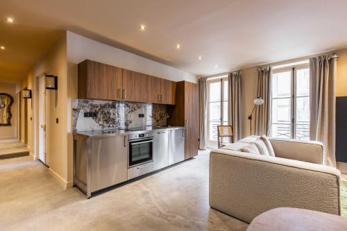 une cuisine avec des appareils en acier inoxydable et des armoires en bois dans l'établissement Magnificent apartment - 5BR-12P - Louvre-Rivoli, à Paris