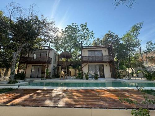 an exterior view of a house with a swimming pool at Villa Natural en Chemuyil in Balcheil