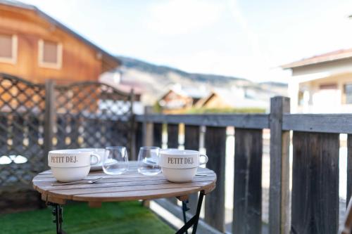 une table en bois avec deux tasses et des verres dans l'établissement Apartment with terrace and parking heart of Megève, à Megève
