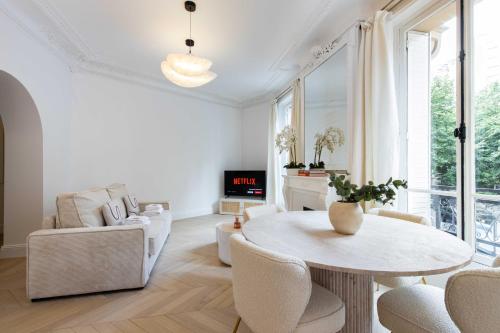 un salon blanc avec une table et des chaises dans l'établissement Charming flat - 2BD-6P - Eiffel Tower, à Paris