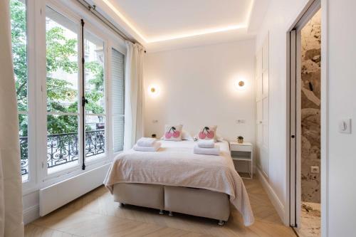 une chambre avec un lit et une grande fenêtre dans l'établissement Charming flat - 2BD-6P - Eiffel Tower, à Paris