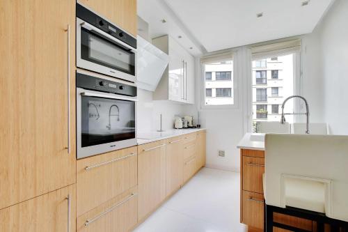 une cuisine avec un évier et un micro-ondes dans l'établissement Charming Appt with a-c- 1bd-2p - Tour Eiffel, à Paris