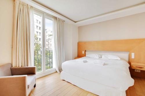 une chambre avec un grand lit blanc et une fenêtre dans l'établissement Charming Appt with a-c- 1bd-2p - Tour Eiffel, à Paris