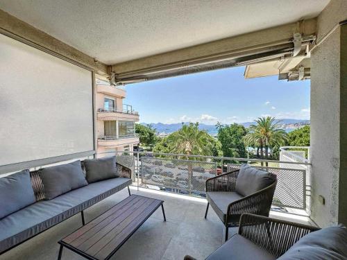 d'un salon avec un canapé et des chaises sur un balcon. dans l'établissement Luxurious Apartment Sea View Terrace La Croisette, à Cannes