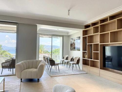 un salon avec une télévision, une table et des chaises dans l'établissement Luxurious Apartment Sea View Terrace La Croisette, à Cannes