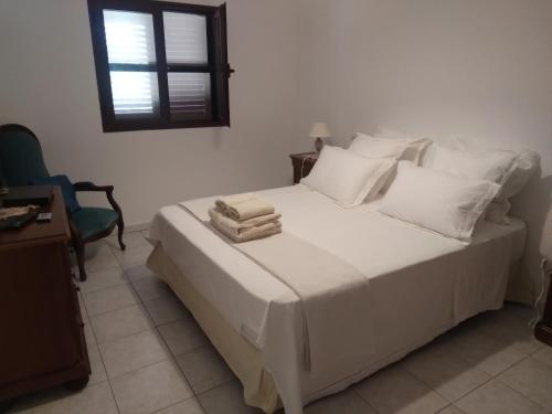 a bedroom with a white bed with towels on it at Entre mer et maquis- maison avec piscine privée - 8 minutes plage tizzano in Sartène