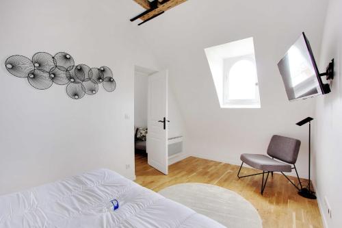 une chambre blanche avec un lit et une chaise dans l'établissement Charming apartment - 1BR-3P -Trocadero, à Paris