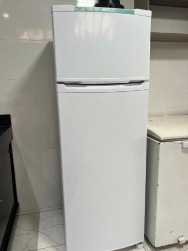 a white refrigerator freezer sitting in a kitchen at Espaço de festas e Hospedagem Cintia Lima in Betim