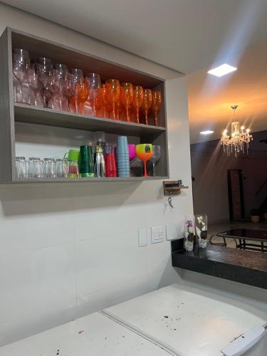 a shelf with glasses on it in a kitchen at Espaço de festas e Hospedagem Cintia Lima in Betim